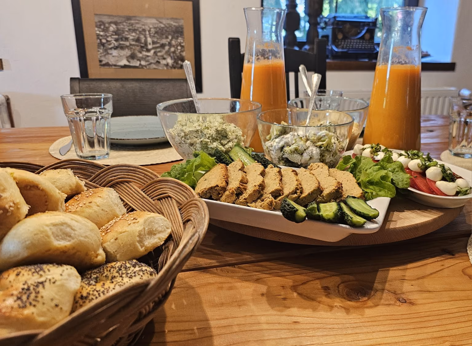 Stół śniadaniowy z pieczywem, kanapkami, warzywami i sokiem
